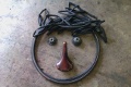 Old bike tire, cassette, seat and inner tubes arranged in a smiley face